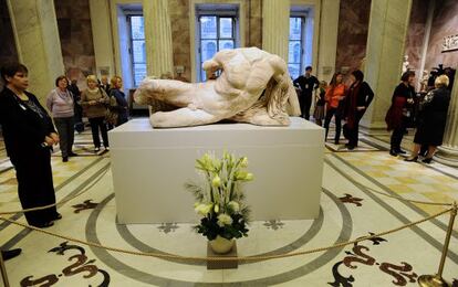 Visitantes del Museo Hermitage San Petersburgo observan la escultura del dios fluvial Ilissos este 5 de diciembre.