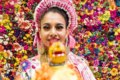 Una joven enmarcada por flores artesanales confeccionadas con hojas de maíz en el estand de México en la Feria Internacional de Turismo de Madrid (Fitur).
