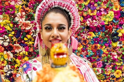 Una joven enmarcada por flores artesanales confeccionadas con hojas de maíz en el estand de México en la Feria Internacional de Turismo de Madrid (Fitur).