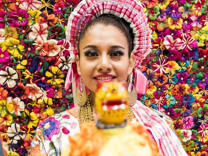 Una joven enmarcada por flores artesanales confeccionadas con hojas de maíz en el estand de México en la Feria Internacional de Turismo de Madrid (Fitur).