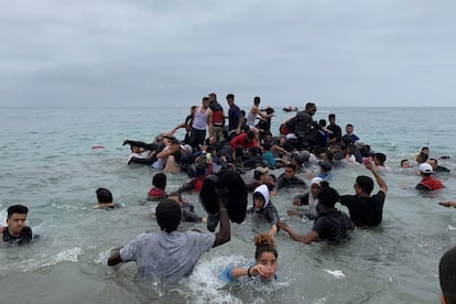 Um grupo de pessoas assumem uma embarcação das autoridades marroquinas na praia da localidade de Fnideq (Castillejos) para cruzar os quebra-mares de Ceuta, nesta terça-feira. O Exército se dirigiu dirigiu aos navios do Tarajal, onde se concentrava a boa parte dos imigrantes, principalmente os menores de idade. Também levaram veículos blindados à praia do Tarajal.