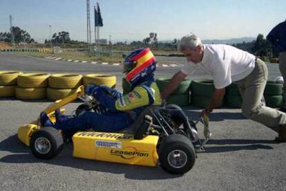 El padre de Alonso, José Luis, empuja el <i>kart</i> de su hijo en una pista de Oviedo.