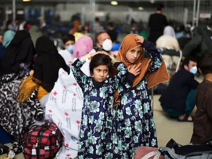 Dos niñas afganas evacuadas del país esperan la llegada de otros compatriotas en un hangar de la base aérea esatadounidense en Ramstein, Alemania.