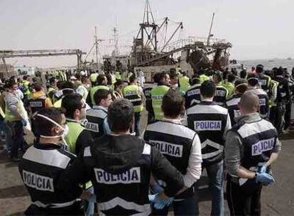 Policías españoles supervisan el desembarco de los inmigrantes del <i>Marine I </i>en el puerto de Nuadibú.