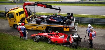 La grúa retira los coches de Alonso y Raikkonen tras su accidente