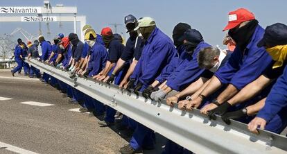 Trabajadores de Delphi arrancan las protecciones para cortar la carretera de acceso a Cádiz, el pasado mayo.