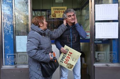 Una mujer felicita al lotero de la administración de la calle Alcalá 323 por vender el tercer premio.