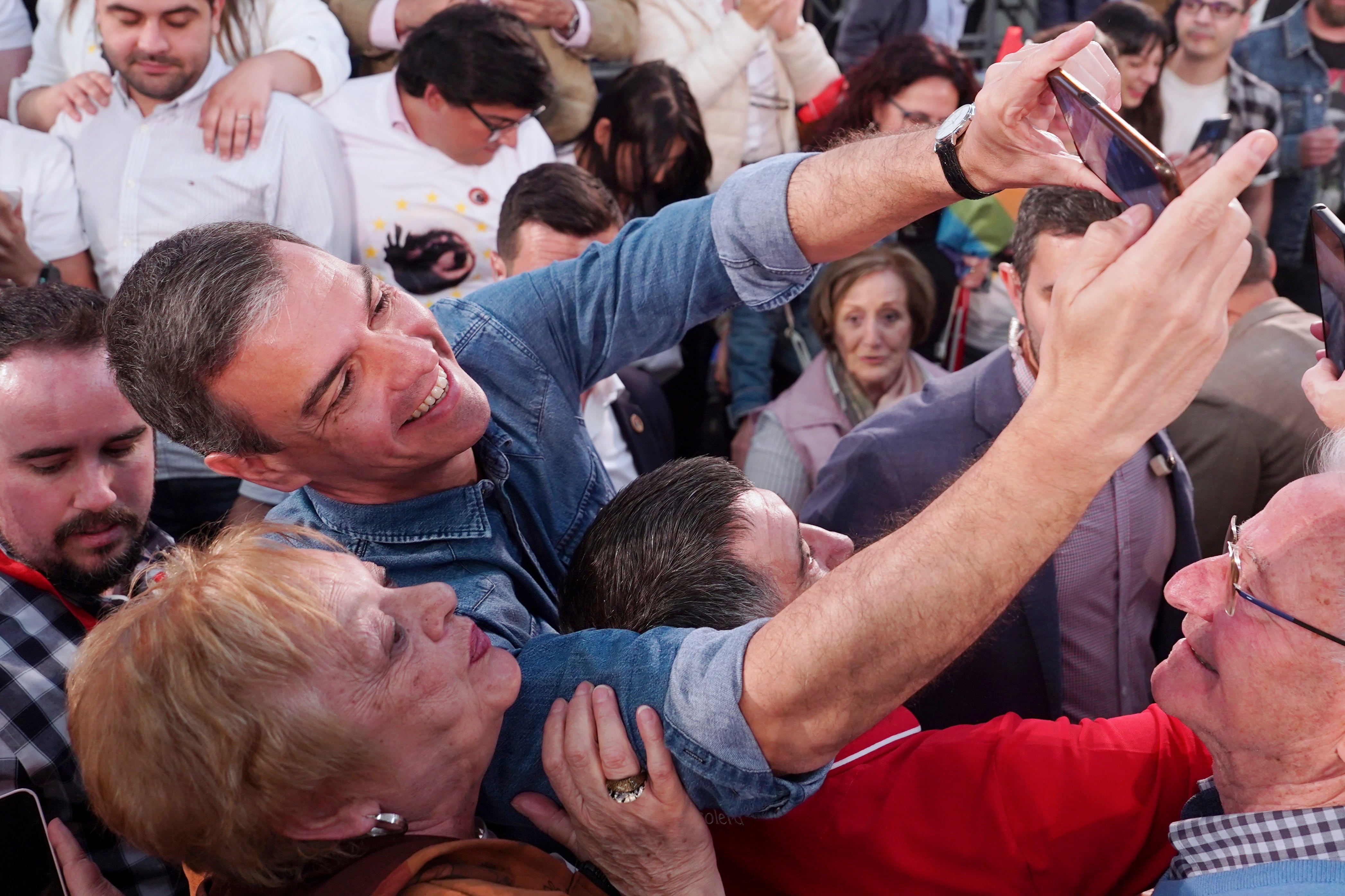 El presidente del Gobierno y secretario general del PSOE, Pedro Sánchez (centro), se hace una foto junto a una simpatizante en Los Alcázares (Murcia), el 31 de mayo. 