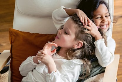 Dos niñas se ríen en la cama.