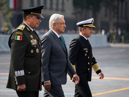 El presidente de México, Andrés Manuel López Obrador, cruza el Zócalo entre el secretario de la Defensa y el secretario de Marina.