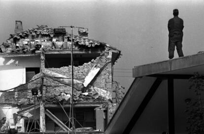 Un guardia civil, subido en el tejado de una casa, frente a las ruinas de la Casa Cuartel de Vic (Barcelona), después del atentado de ETA en mayo de 1991. 