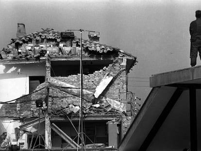 Un guardia civil, subido en el tejado de una casa, frente a las ruinas de la Casa Cuartel de Vic (Barcelona), después del atentado de ETA en mayo de 1991. 
