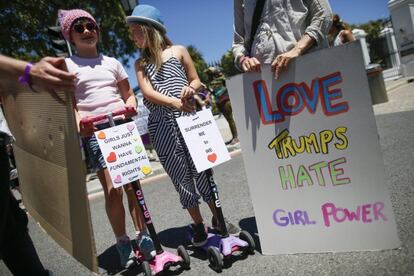 No patín esquerdo: "As garotas só querem direitos fundamentais". É um jogo de palavras com a canção "Girls wanna have fun" de Cindy Lauper. No patín direito "Rendo-me pelo que amamos". No terceiro cartaz: "Amamos o que Trump Odeia. Mulheres ao Poder". Tomada em Cidade do Cabo, África do Sul