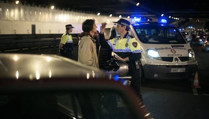 Un agente de la Guardia Urbana hace el control de alcoholemia a un conductor.