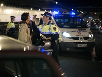 Un agente de la Guardia Urbana hace el control de alcoholemia a un conductor.