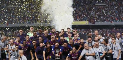 Los jugadores y el cuerpo técnico del FC Barcelona posan con el trofeo tras la final de la Supercopa de España.