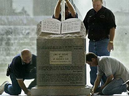 Varios empleados retiran un monumento a los Diez Mandamientos de un juzgado del Alabama, en 2003.