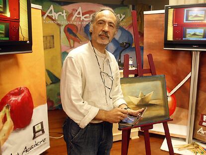 El artista José Ibarrola, ayer en Bilbao, ante uno de sus cuadros con la consola de Nintendo en las manos.