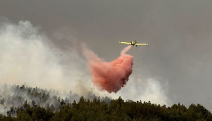 Un avión descarga espuma en uno de los frentes del fuego en Bejís.