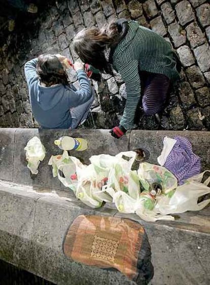 Dos adolescentes hacen <i>botellón</i> en una plaza del Casco Viejo de Vitoria.