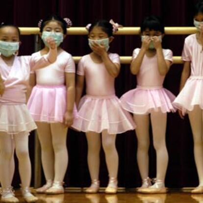 Un grupo de niñas participa con mascarillas en una clase de danza. La imagen fue tomada ayer en Hong Kong.