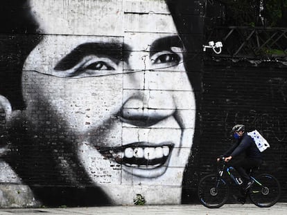 Un hombre con barbijo pasa con su bicicleta delante de un mural con el rostro de Carlos Gardel, en Buenos Aires, el 4 de mayo de 2020.