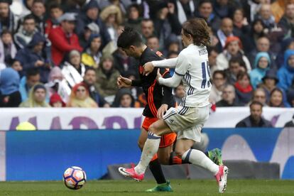 El centrocampista croata del Real Madrid Luka Modric (d) agarra al valencianista Carlos Soler (i).