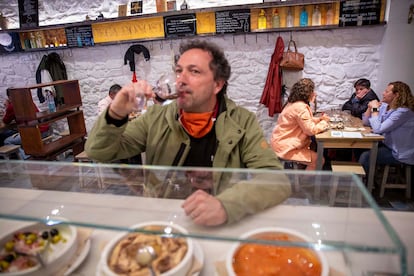 Un cliente toma un vino en la barra de la Bodega Donostiarra.