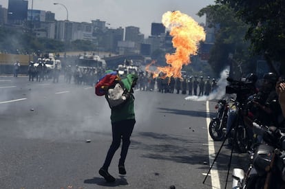 Un joven se enfrenta a los policías antidisturbios durante una manifestación en Caracas.