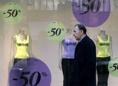 Un hombre pasa delante de un escaparate con rebajas en una tienda de Valencia.