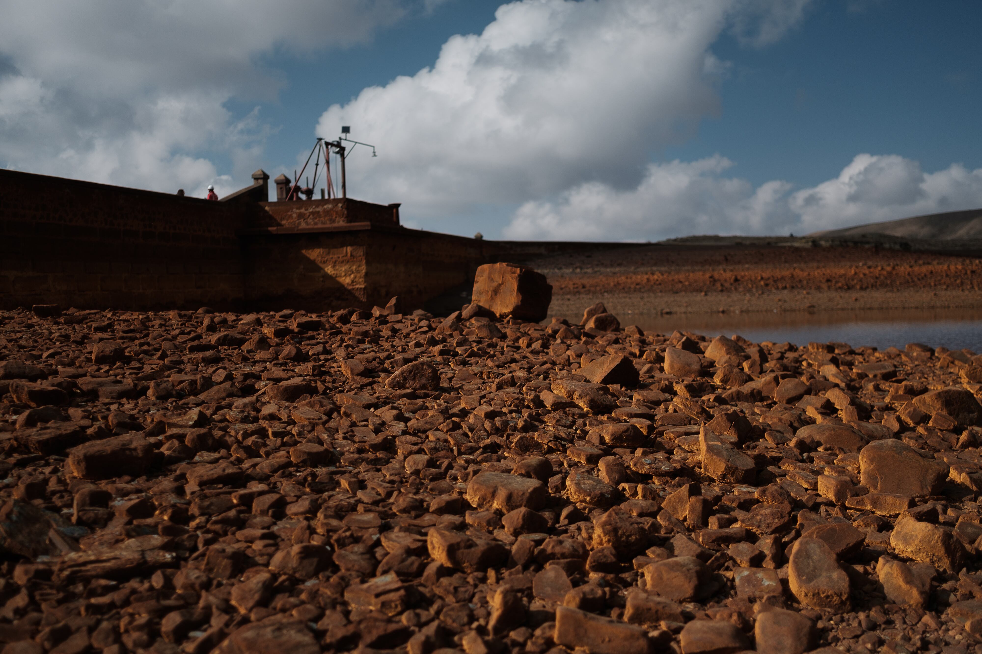 Lecho de la represa de Milluni, que se encuentra al 12% de su capacidad. El color de la tierra es producto de los pasivos ambientales arrojados por las minas que se asientan en los alrededores.