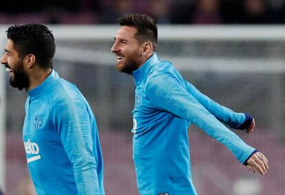 Luis Suárez calienta con Lionel Messi, antes del partido.