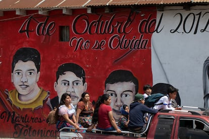 Un grupo de jóvenes pasa frente a uno de los murales de Totonicapán, este lunes.