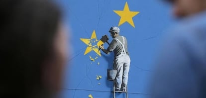 Una persona mira un mural de Banksy