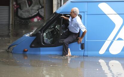 Un hombre sale de su coche por la ventanilla después de quedarse bloqueado en una calle inundada, en Estambul (Turquía). Varios barrios de Estambul han quedado anegados por las fuertes lluvias de las últimas horas, las más intensas en ocho años, que han paralizado gran parte del tráfico urbano y han obligado a cerrar el túnel bajo el Bósforo y distintas líneas de metro.