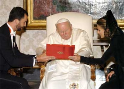 Juan Pablo II observa el regalo de los Príncipes de Asturias: una imagen en plata de la Virgen del Pilar.