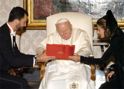 Juan Pablo II observa el regalo de los Príncipes de Asturias: una imagen en plata de la Virgen del Pilar.