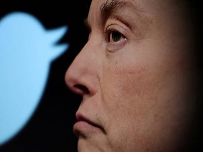 Elon Musk, dueño de Twitter, junto a un logo de la red social.