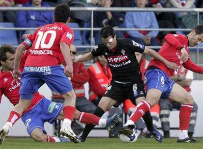 Barkero, Moreno y Nagore tratan de arrebatarle el balón a Carmelo.