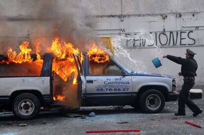 Zona Rosa. Delegación Cuauhtemoc.  Un policía intenta apagar el incendio en una camioneta tras un enfrentamiento entre dos grupos de trabajadores por el conflicto laboral  de un estacionamiento público.