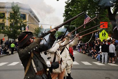 Varios participantes disparan armas de fuego durante el desfile anual del Memorial Day, en Naugatuck, Connecticut.  