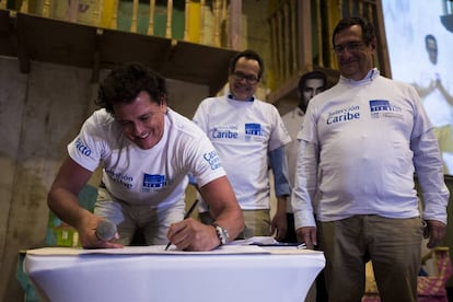 El cantante Carlos Vives firma el compromiso de inversión de Casa Grande Caribe, junto a Marco Schwartz, director de 'El heraldo de Barranquilla', y Adolfo Meisel, codirector del Banco de la República.