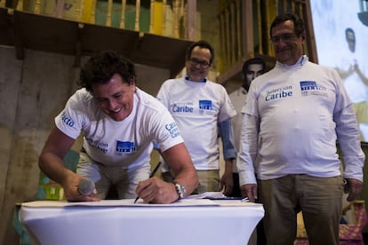 El cantante Carlos Vives firma el compromiso de inversión de Casa Grande Caribe, junto a Marco Schwartz, director de 'El heraldo de Barranquilla', y Adolfo Meisel, codirector del Banco de la República.