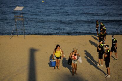 Bañistas abandonana la playa del Bogatell porque se cierran para la verbena de Sant Joan.