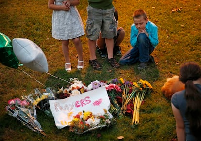 Unos niños muestran su respeto en un altar improvisado tras los asesinados en el tiroteo de Roseburg (EE UU). En un sólo día se han recopilado casi 700.000 dólares a través de una campaña difundida en internet destinada a pagar el tratamiento y recuperación de un militar estadounidense que ha sido calificado como el "héroe" de la masacre en el campus universitario de Oregón.