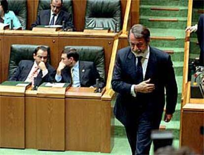 Jaime Mayor Oreja (PP) pasa junto a Juan José Ibarretxe (PNV) en el pleno del Parlamento vasco.