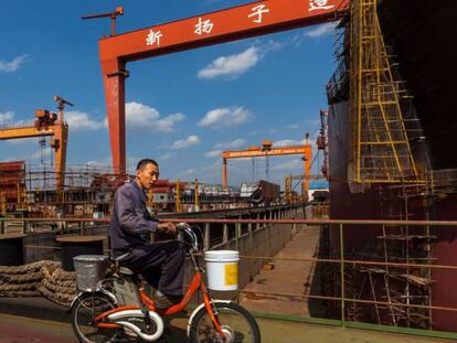 Un trabajador circula en bicicleta por los astilleros de Yangzijiang en Jiangyin en la provincia de Jiangsu.