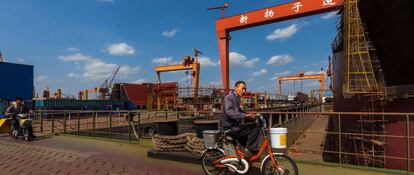 Un trabajador circula en bicicleta por los astilleros de Yangzijiang en Jiangyin en la provincia de Jiangsu.