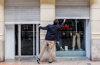 El propietario de un comercio cierra su establecimiento de Valencia el pasado jueves.