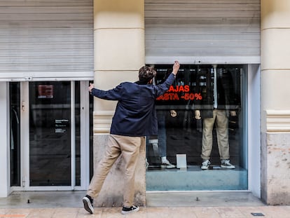 El propietario de un comercio cierra su establecimiento de Valencia el pasado jueves.